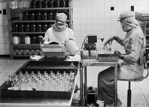 Imagen en blanco y negro de dos personas trabajando en un laboratorio farmaceutico
