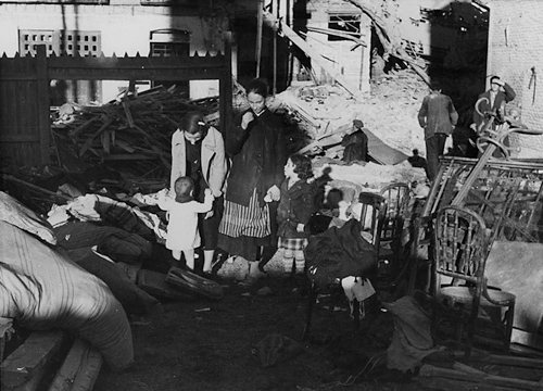 Dos mujeres con dos niños junto a las ruinas de un edificio en Madrid durante la Guerra civil