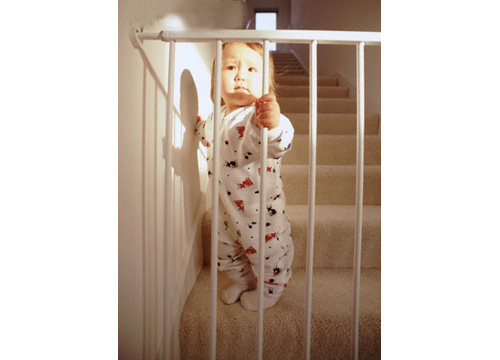 Bebé en una escalera agarrandose a una reja de seguridad